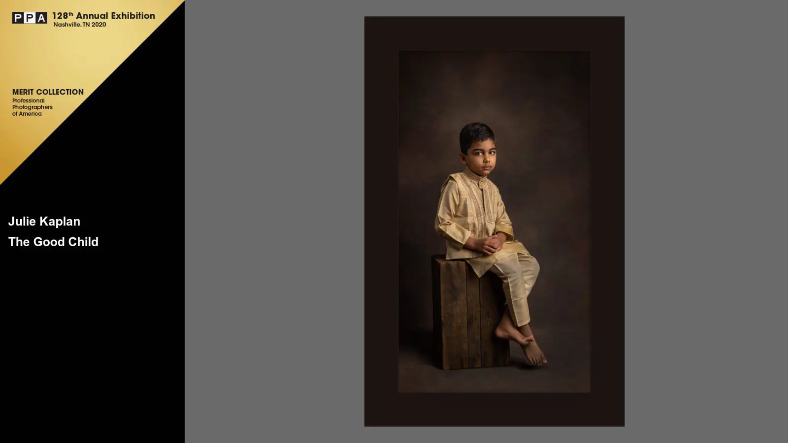 A young boy sitting on top of a wooden box.