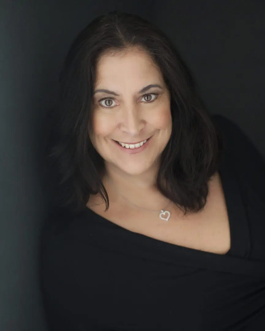 A woman in black shirt smiling for the camera.