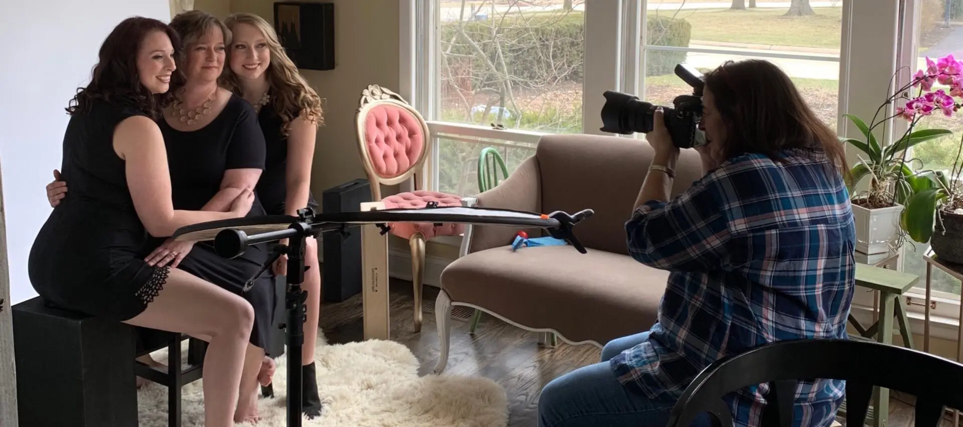 A woman is being filmed by a man in a chair.