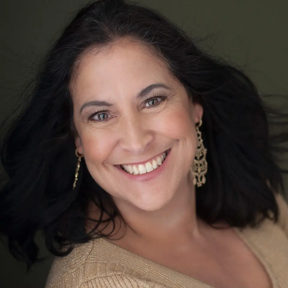 A woman with long black hair smiling for the camera.