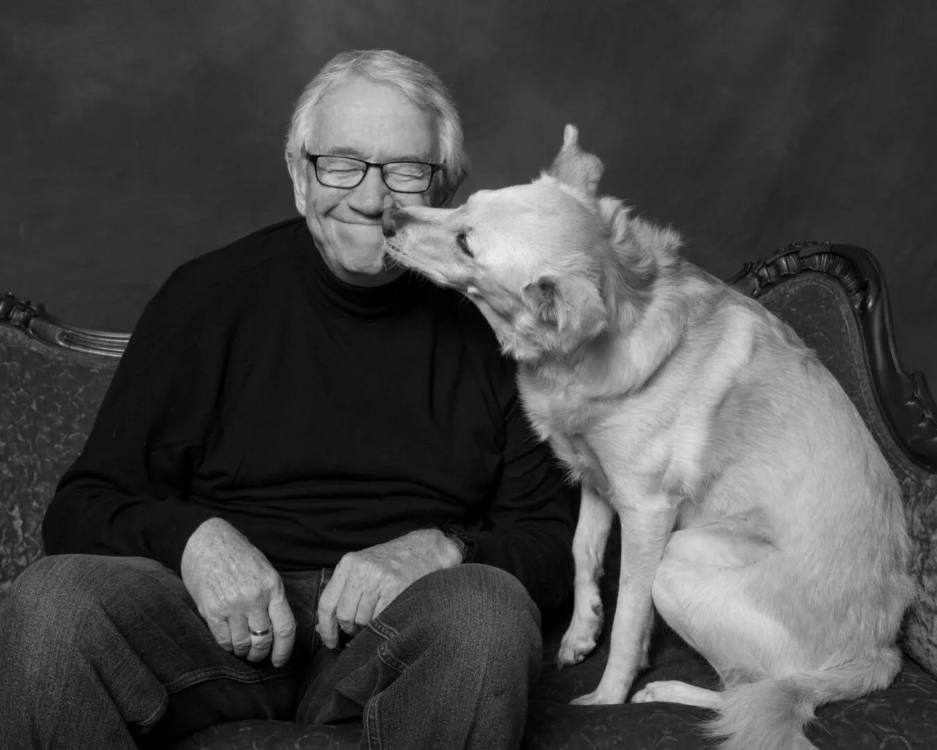 A man and his dog are sitting on the couch.